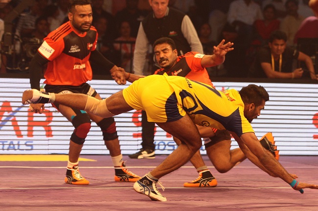 Sukesh Hegde of Telugu Titan escapes from the clutches of U Mumba defenders Jeeva Kumar and Vishal Mane who in the background looking on in the Star Sports Pro Kabaddi season 3 opener