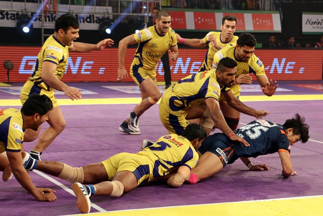 Jang Kun Lee of Bengal Warriors trying to escape from the hold applied by Dharamaraj Cheralathan and Sukesh Hegde of Telugu Titans