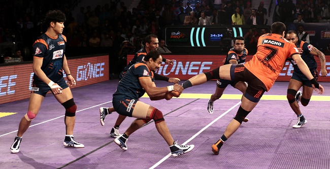 Bengal Warriors captain Nilesh Shinde shows his defensive prowess as he grabs hold of Rakesh Kumar by the ankle to pull him back and prevent him from getting to the midline