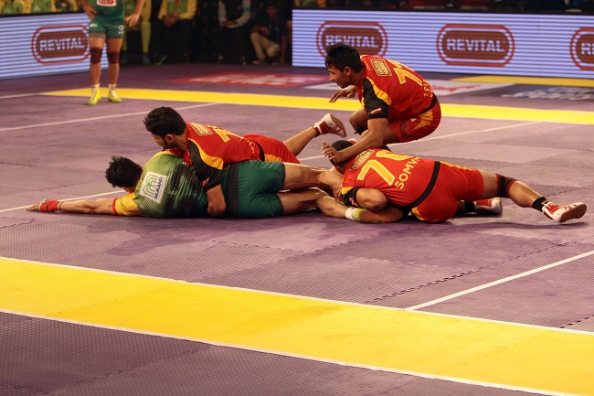 Patna Pirates new find Rohit Kumar uses his agility and power to wriggle out of the ankle hold affected by Bengaluru Bulls Somvir (70) & Shrikant Tewthia in Match No. 8 of the Star Sports Pro Kabaddi
